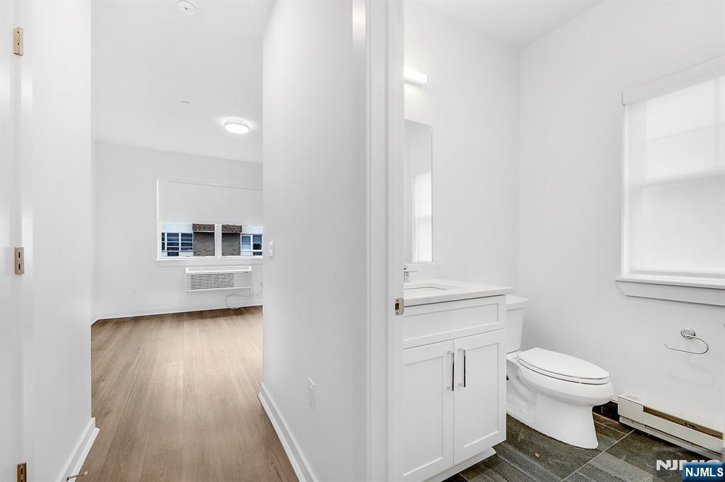 74 Clarendon Place, Unit 202 Hackensack, NJ 07601 - Photo 20 of 33 a bathroom with a toilet a sink and a window