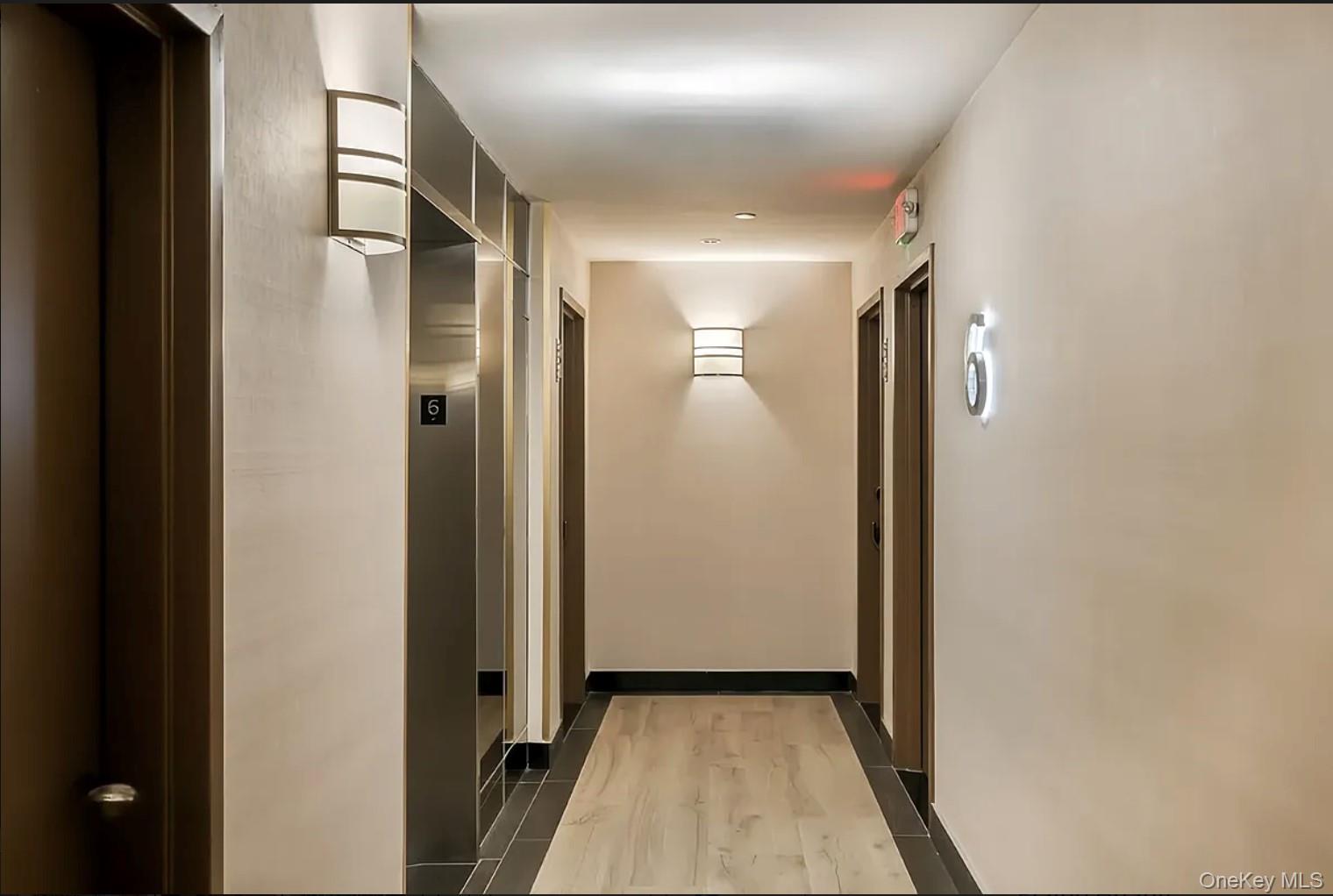 41-04 27th Street, Unit 9A Queens, NY 11101 - Photo 10 of 14 a view of a hallway with wooden floor