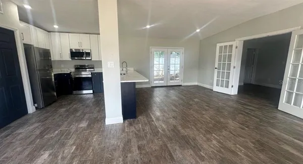 a view of a kitchen with refrigerator stove and wooden floor