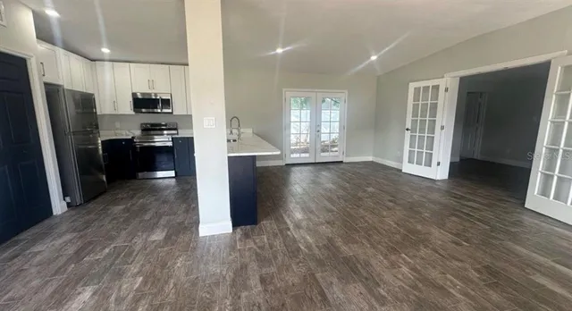a view of a kitchen with refrigerator stove and wooden floor