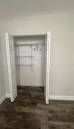 an empty room with wooden floor and cabinet