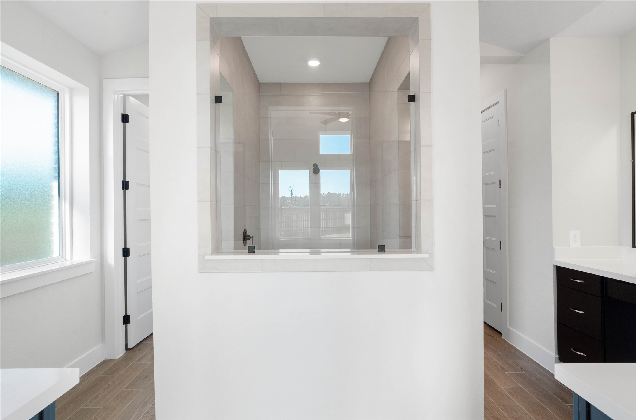 2114 Rowl Street Montgomery, TX 77316 - Photo 35 of 50 The primary bathroom is a masterclass in modern layout and light. At its center sits an oversized walk-in shower featuring a unique glass "window" that adds depth and a sense of openness to the entire suite.
