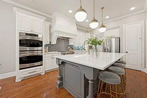 a kitchen with kitchen island granite countertop a sink cabinets and stainless steel appliances