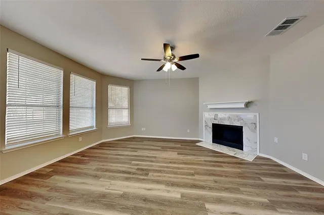 a view of an empty room with a fireplace and a window