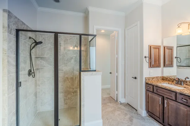 a bathroom with a granite countertop sink a mirror and a shower