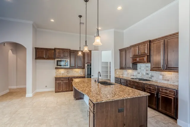 a kitchen with stainless steel appliances granite countertop a sink stove and refrigerator
