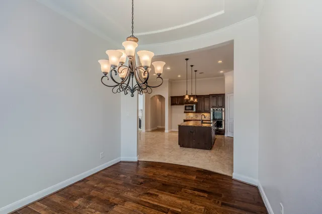 a view of a livingroom with a chandelier furniture and wooden floor