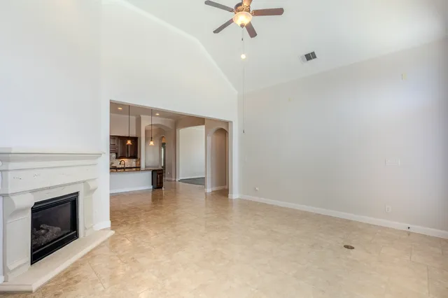 a view of a livingroom with a fireplace and a chandelier fan