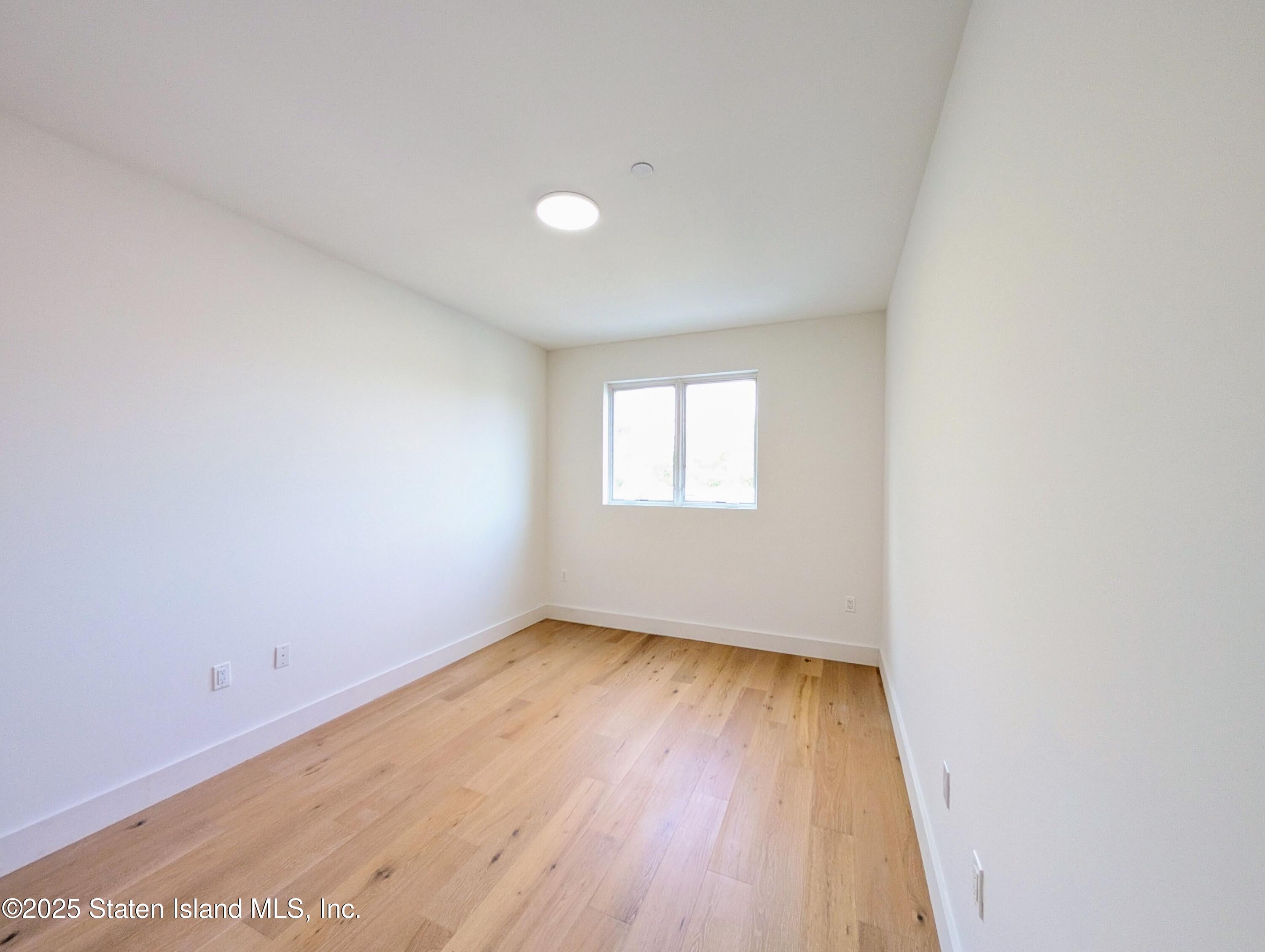 3865 Amboy Road, Unit 4D Staten Island, NY 10308 - Photo 16 of 30 an empty room with wooden floor and windows