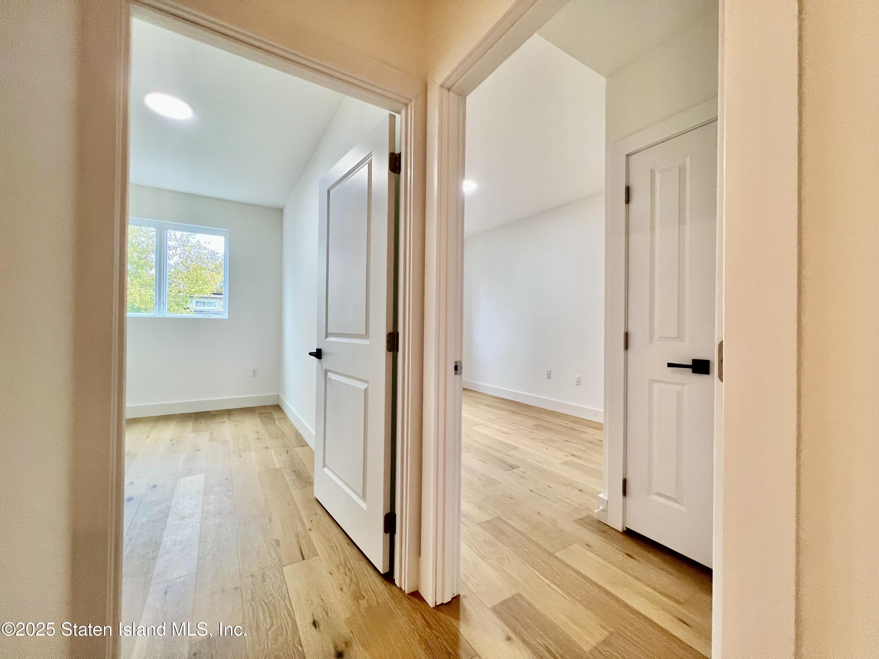 3865 Amboy Road, Unit 4D Staten Island, NY 10308 - Photo 22 of 30 a view of a hallway with wooden floor and a bathroom