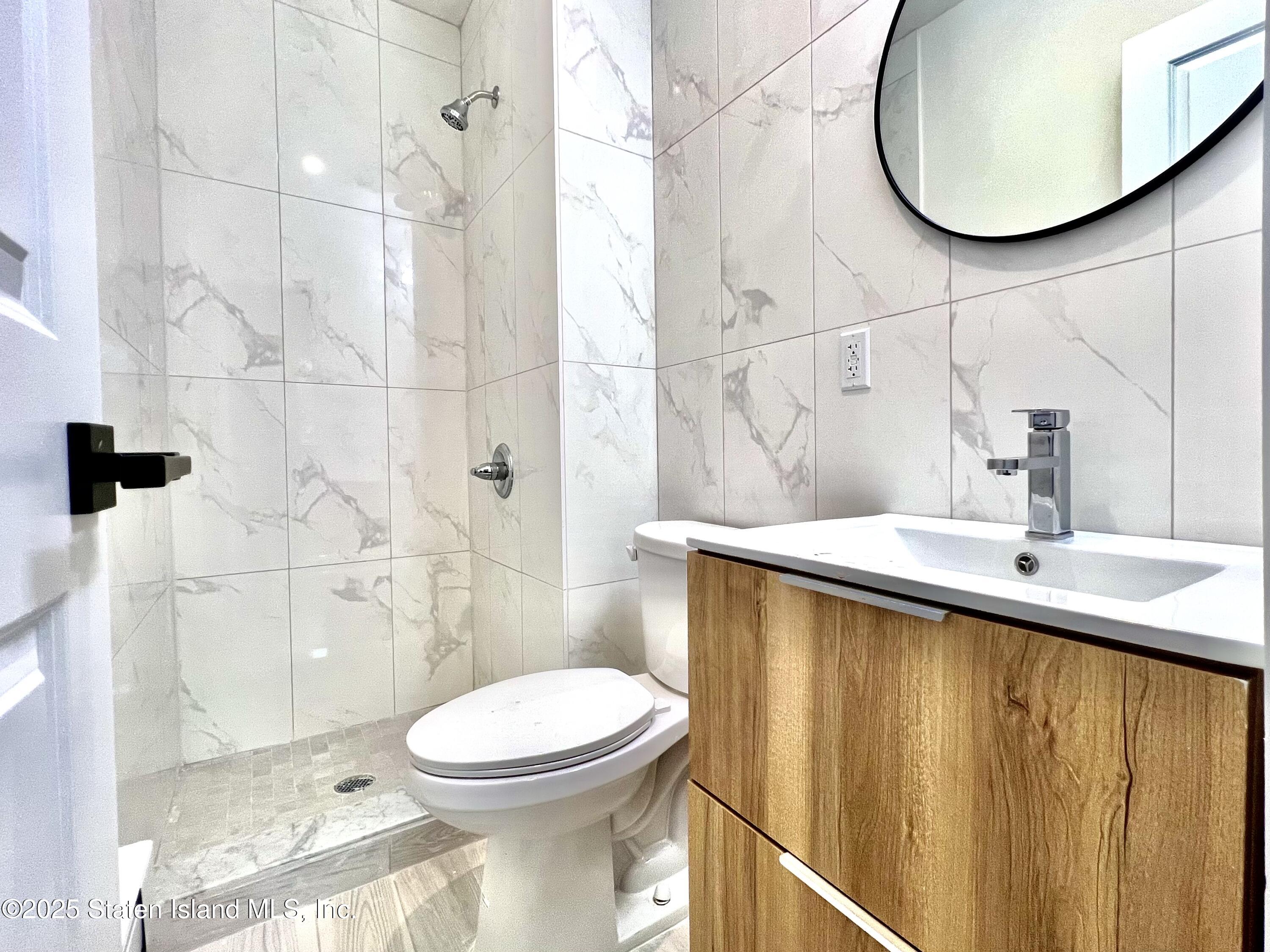 3865 Amboy Road, Unit 4D Staten Island, NY 10308 - Photo 24 of 30 a bathroom with a sink a toilet and shower