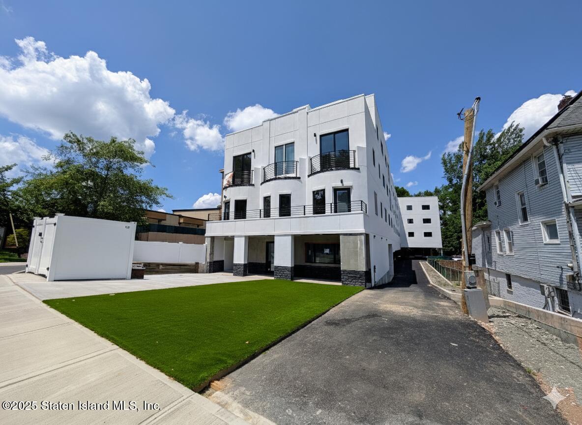 3865 Amboy Road, Unit 4D Staten Island, NY 10308 - Photo 3 of 30 a view of a white house with a big yard plants and large trees