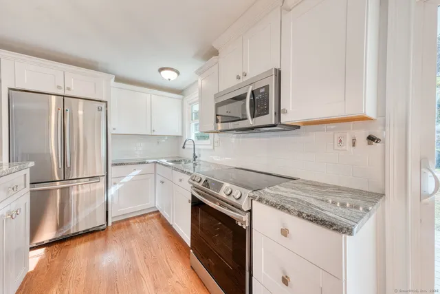 a kitchen with granite countertop a refrigerator stove and microwave