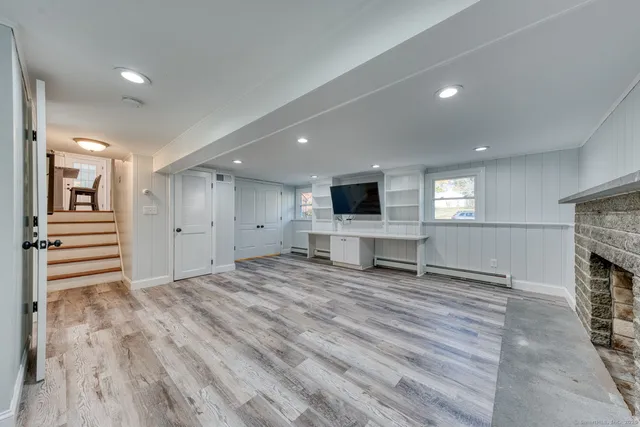 a view of an empty room with a fireplace and a window