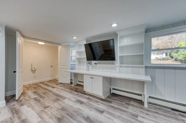 a view of a workspace with furniture and a window