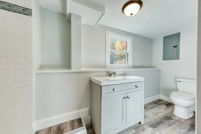 a bathroom with a sink a toilet and window