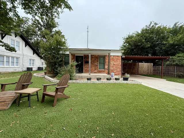 a backyard of a house with table and chairs