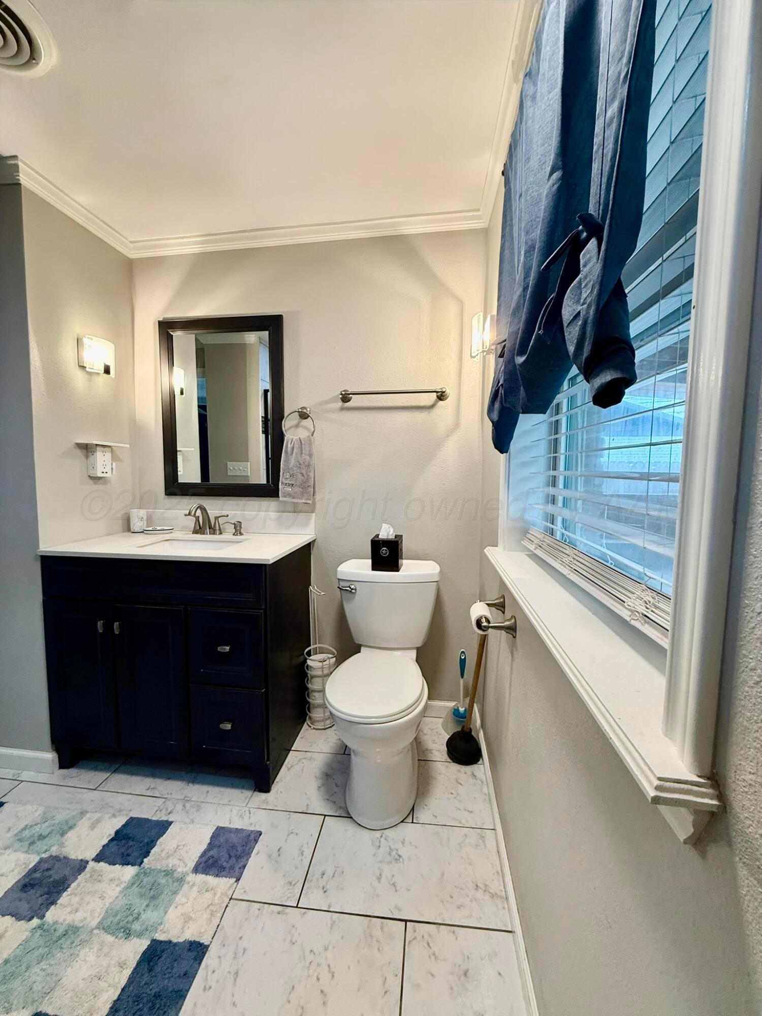 3314 Kingston Road Amarillo, TX 79106 - Photo 13 of 17 a bathroom with a sink a toilet and mirror