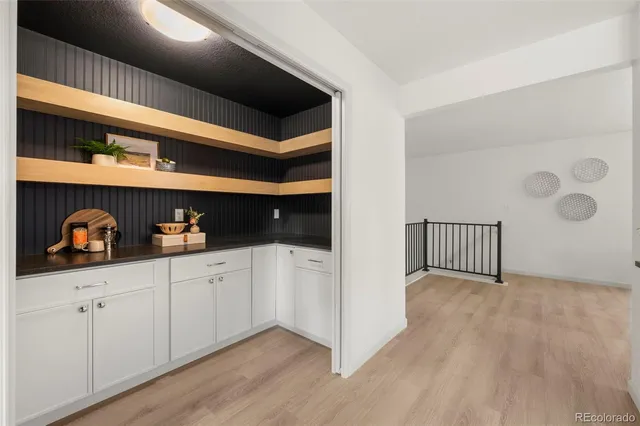 a kitchen with white cabinets and wooden floor