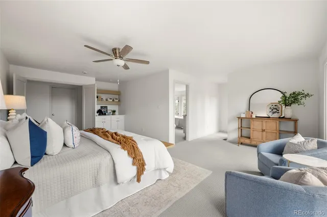 a bedroom with a large bed and ceiling fan