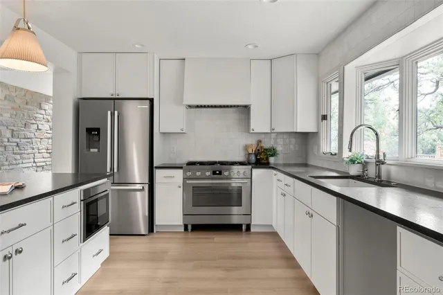 a kitchen with refrigerator a sink and a stove