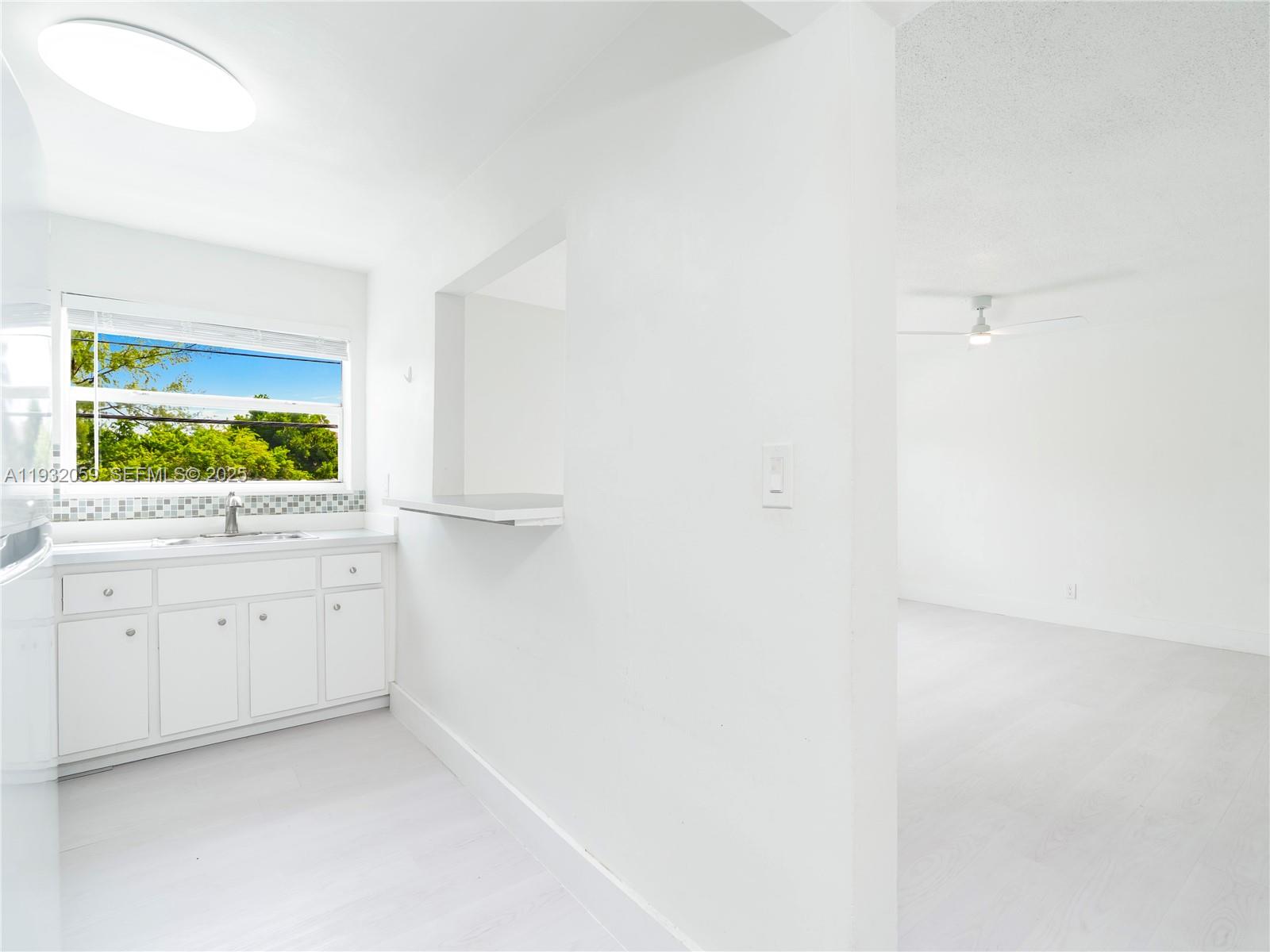 2025 Miami Road, Unit 17 Fort Lauderdale, FL 33316 - Photo 7 of 23 a kitchen with white cabinets and window