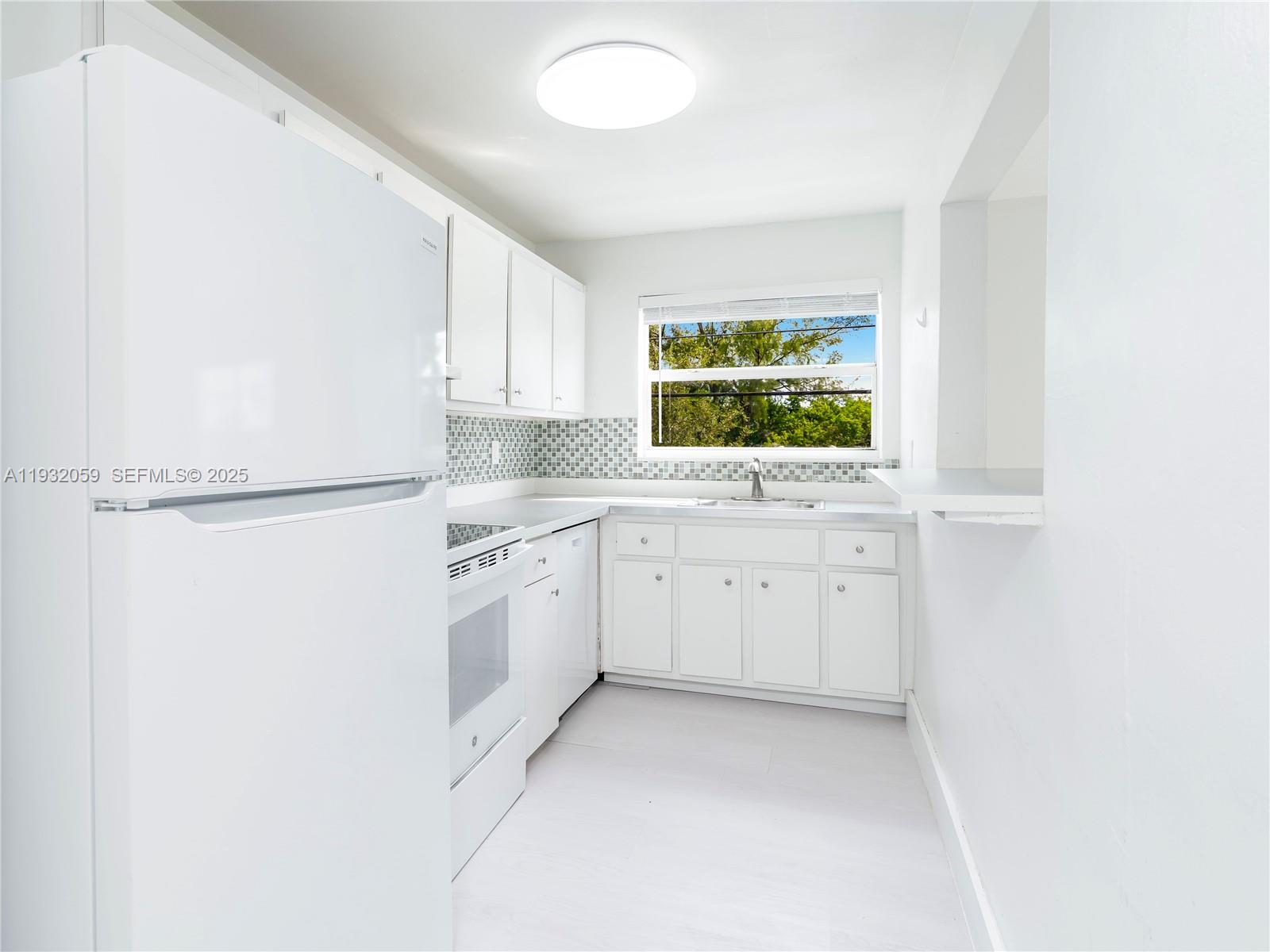2025 Miami Road, Unit 17 Fort Lauderdale, FL 33316 - Photo 8 of 23 a kitchen with white cabinets and white appliances