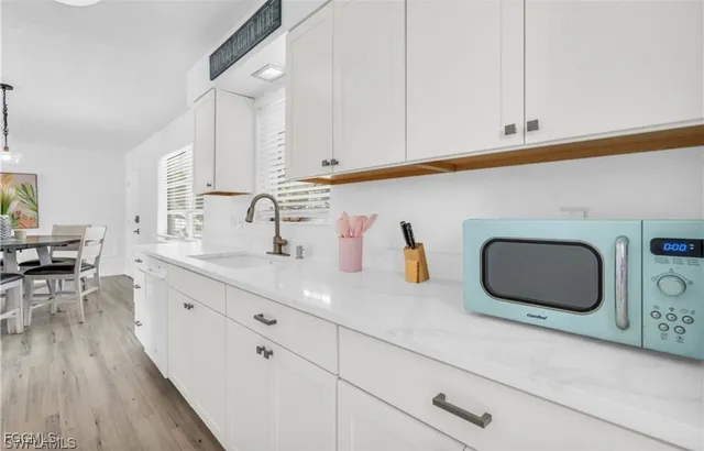 a kitchen with granite countertop a sink a stove and cabinets