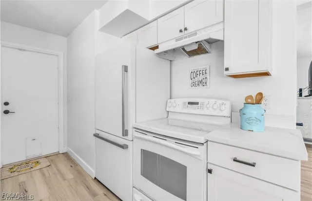 a kitchen with white cabinets and white appliances