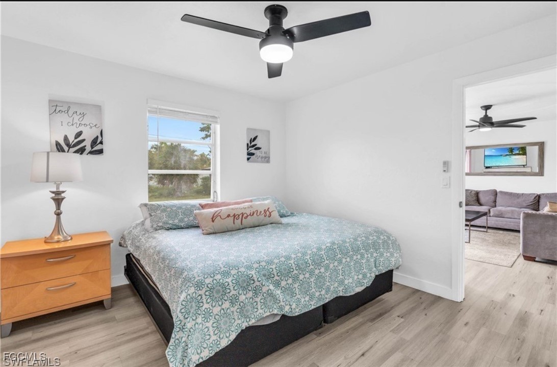 1661 Coronado Road Fort Myers, FL 33901 - Photo 42 of 50 a bedroom with a bed and wooden floor