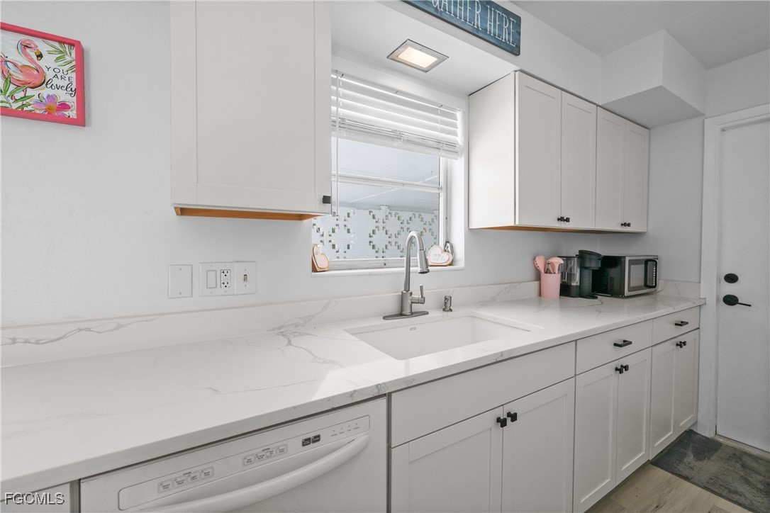 1661 Coronado Road Fort Myers, FL 33901 - Photo 10 of 50 a kitchen with granite countertop white cabinets and white appliances