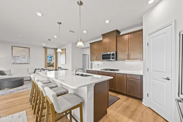 a large kitchen with a counter space a sink appliances and cabinets