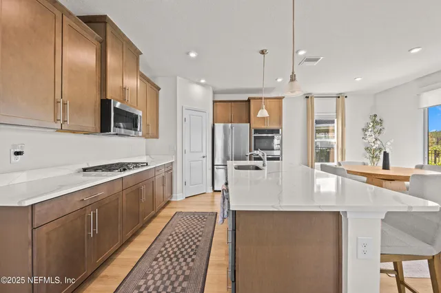 a large kitchen with stainless steel appliances granite countertop a stove and a sink