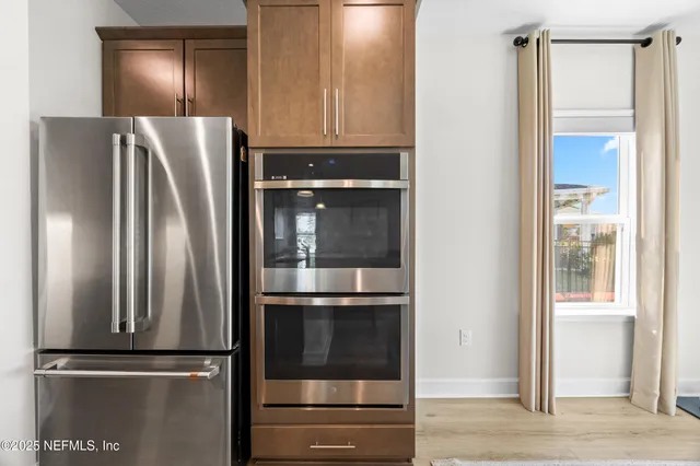 a metallic refrigerator freezer sitting in a kitchen