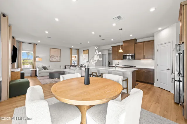 a dining room with kitchen island stainless steel appliances furniture stove and a refrigerator