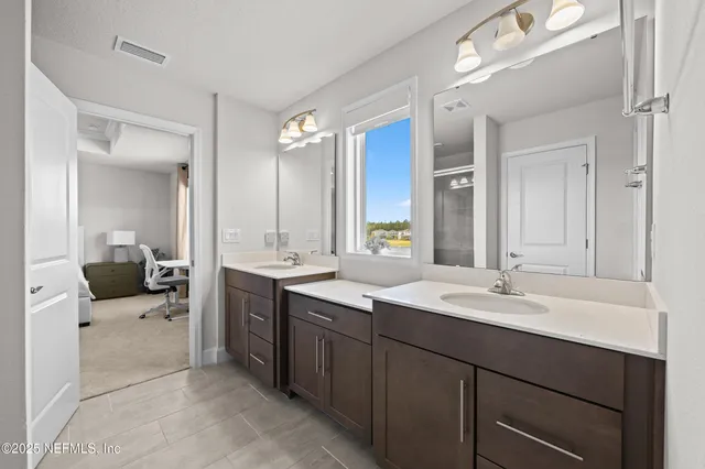 a en suite bathroom with a double vanity sink mirror and