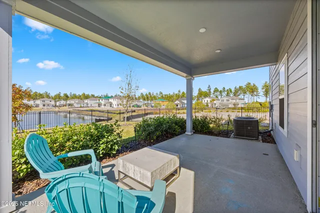 a view of a chairs and table in patio with a lake view
