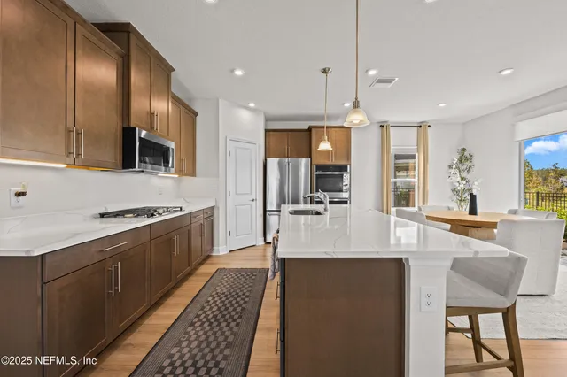 a kitchen with stainless steel appliances granite countertop a sink stove and refrigerator
