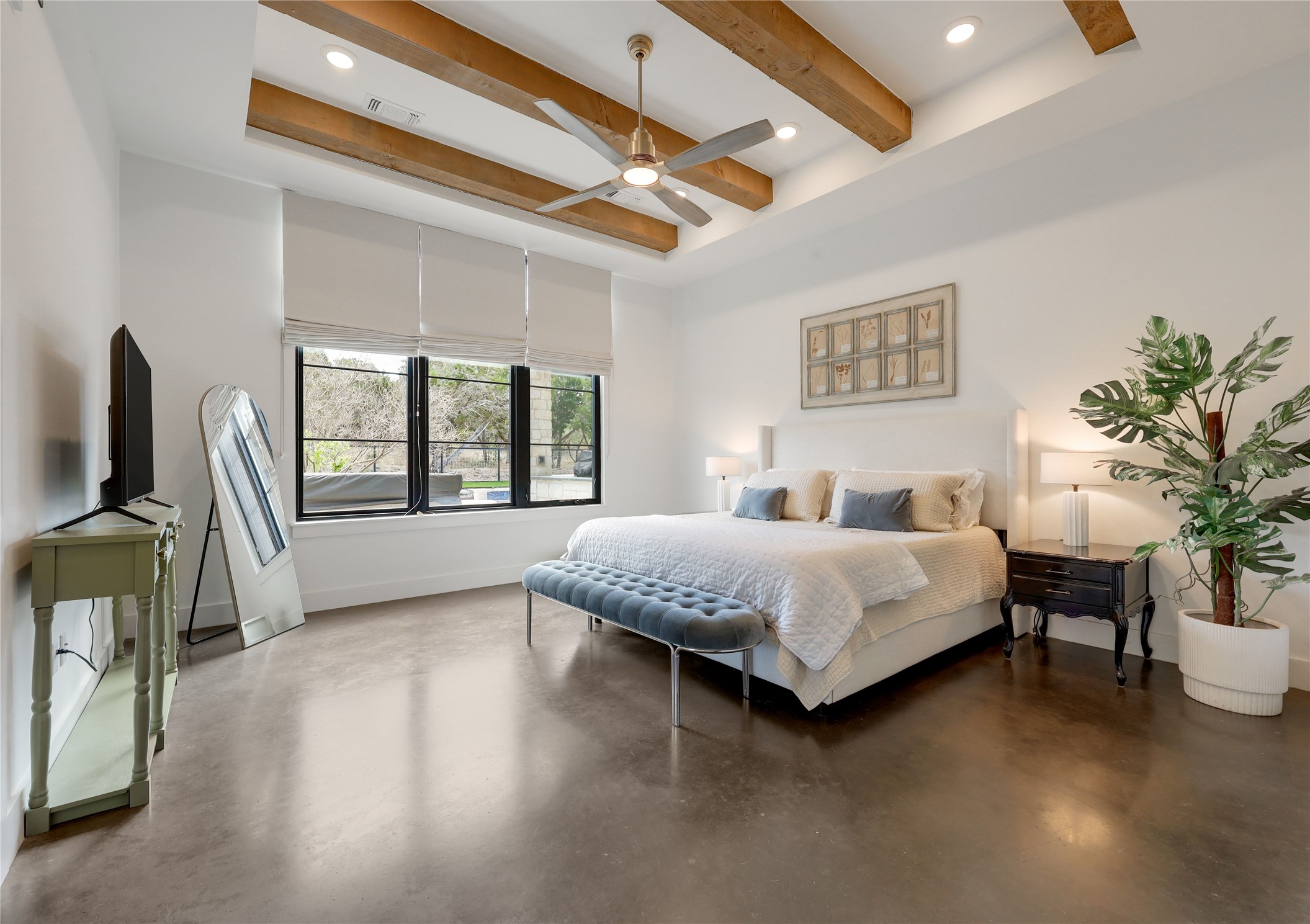 329 Calvary Cove Dripping Springs, TX 78620 - Photo 14 of 40 a spacious bedroom with a large bed and a chandelier