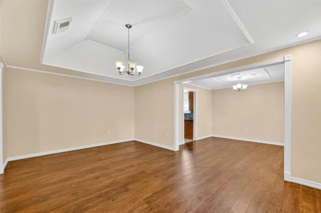 a view of an empty room with wooden floor