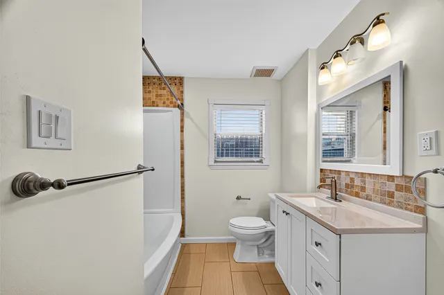 a bathroom with a sink a toilet and a mirror