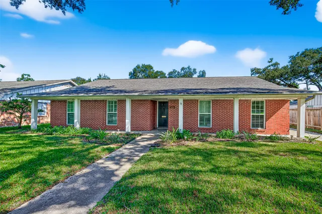 a front view of a house with a garden and yard