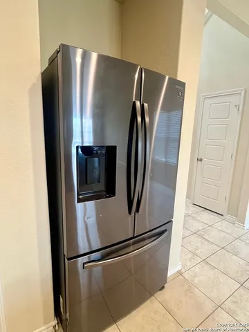 a metallic refrigerator freezer sitting in a kitchen