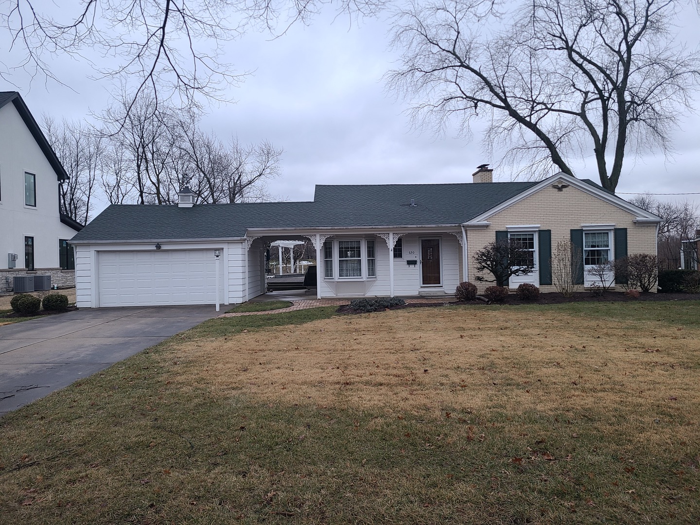 a front view of a house with a garden and trees