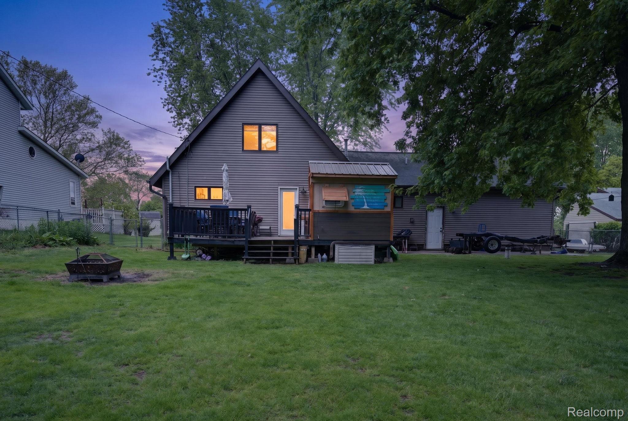 1280 Petts Road Fenton, MI 48430 - Photo 39 of 62 Back of property with an outdoor fire pit and a wooden deck