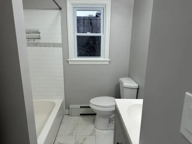 a white toilet sitting next to a bathroom sink and a tub