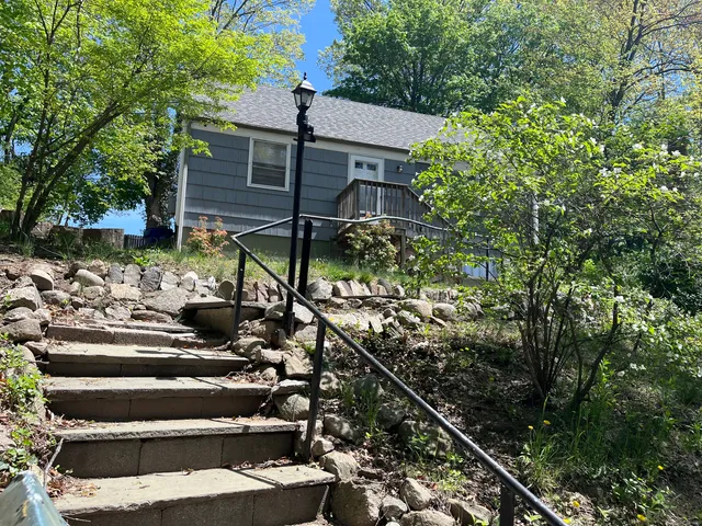 a view of house with yard and sitting area