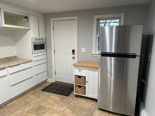 a kitchen with a refrigerator and a stove top oven