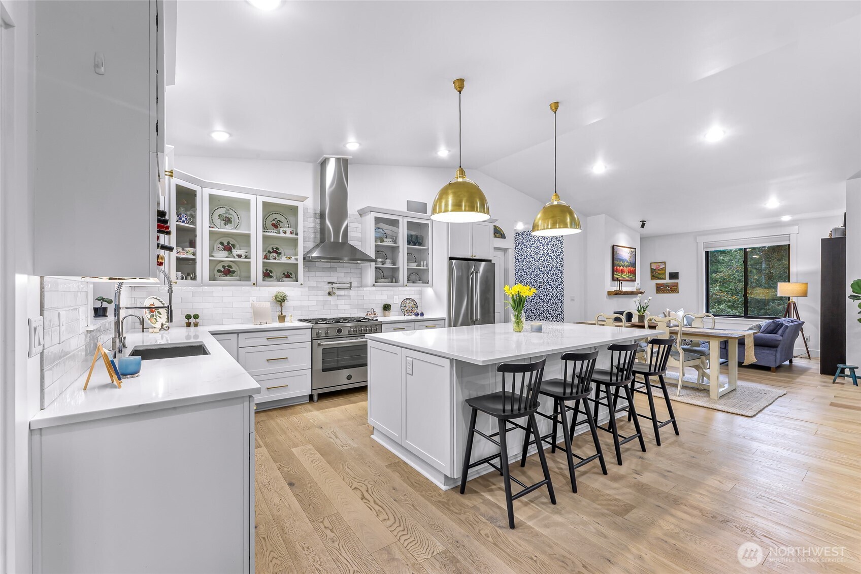 4336 Meander Lane Langley, WA 98260 - Photo 12 of 36 a kitchen with stainless steel appliances granite countertop a stove a sink a kitchen island with chairs and wooden floor