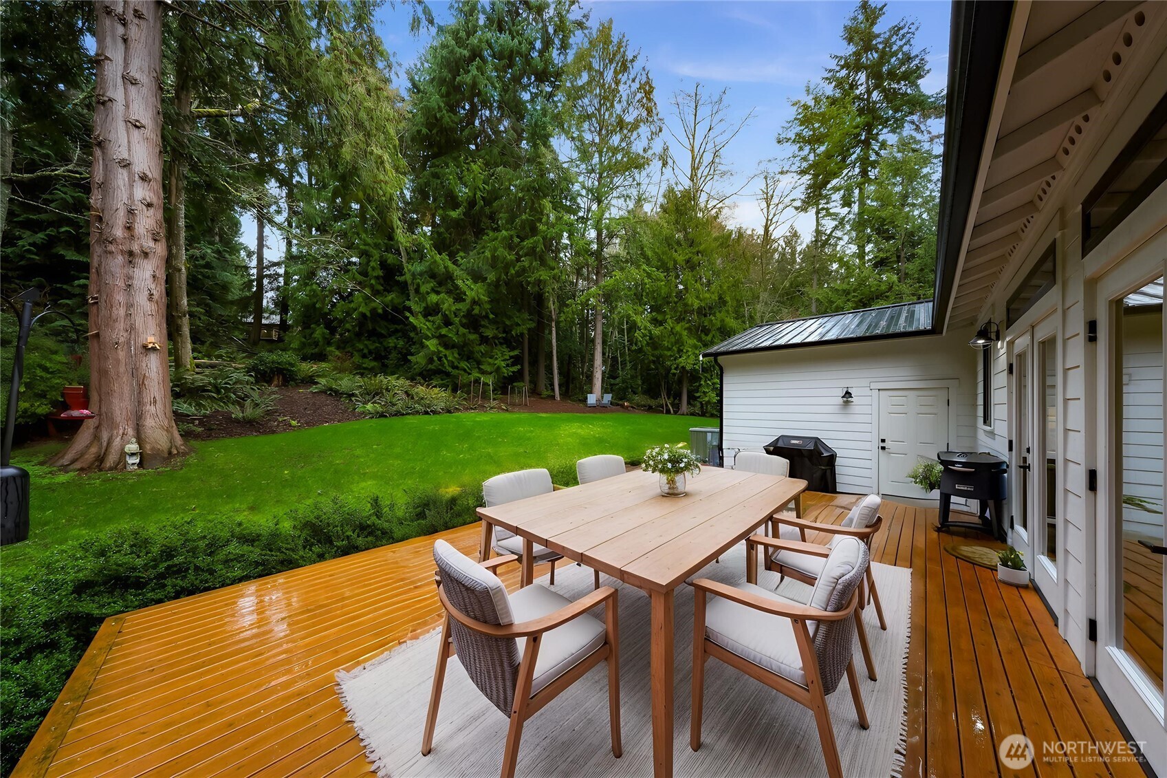 4336 Meander Lane Langley, WA 98260 - Photo 31 of 36 a view of a patio with table and chairs under an umbrella with wooden floor and fence